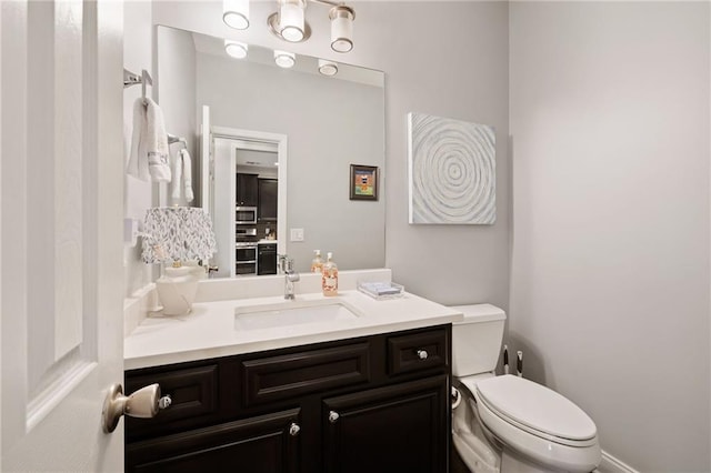 half bathroom featuring vanity and toilet