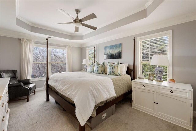bedroom with light colored carpet, crown molding, a raised ceiling, and a ceiling fan