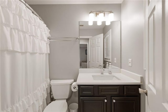 bathroom with curtained shower, toilet, and vanity