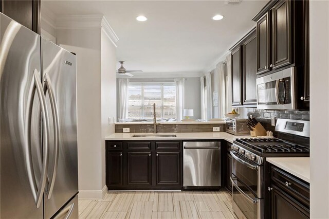 kitchen with tasteful backsplash, stainless steel appliances, light countertops, and a sink