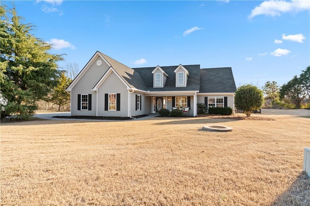 cape cod home featuring a porch and a front lawn