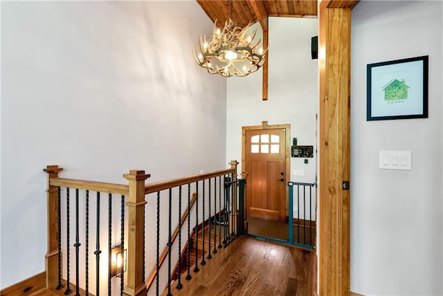 foyer entrance with dark hardwood / wood-style flooring, vaulted ceiling, a notable chandelier, and wooden ceiling