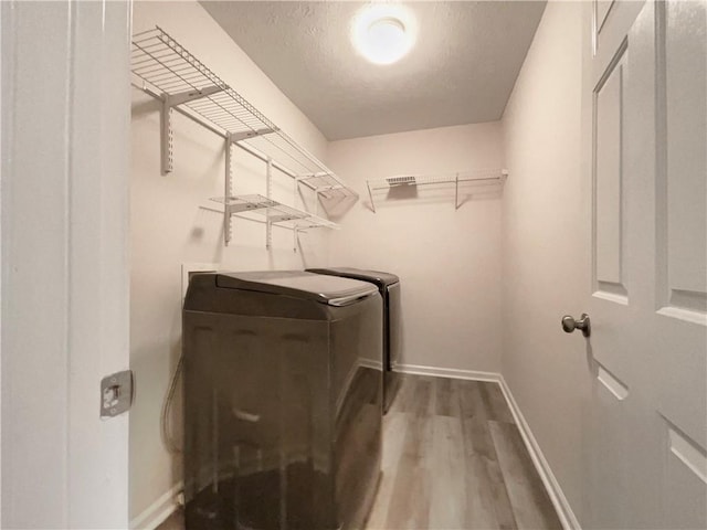 6001 Deer Springs Ln NW, Acworth, GA 30101 - laundry area with independent washer and dryer, wood finished floors, baseboards, and a textured ceiling