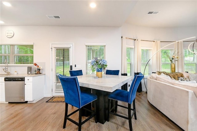 dining space with light wood-type flooring and a wealth of natural light