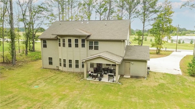 rear view of property featuring a yard and a patio area