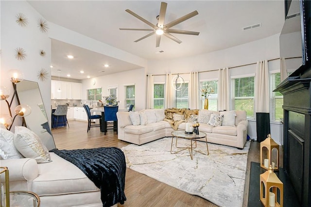 living room with light hardwood / wood-style flooring and ceiling fan