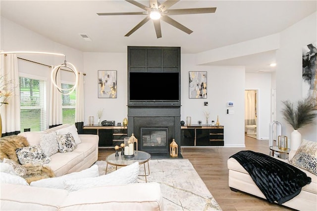 living room with light wood-type flooring and ceiling fan