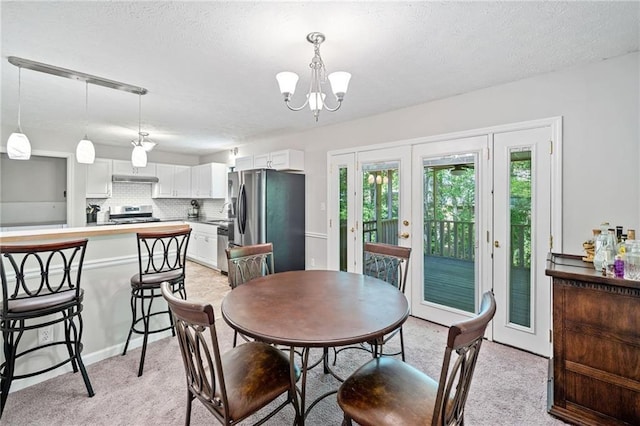 7060 Steel Wood Dr NW, Kennesaw, GA 30152 - dining space with a chandelier, light colored carpet, a textured ceiling, and french doors