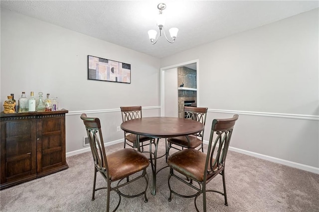 7060 Steel Wood Dr NW, Kennesaw, GA 30152 - carpeted dining room with a stone fireplace, baseboards, a chandelier, and a textured ceiling
