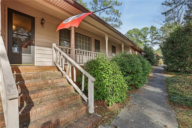 view of side of home featuring covered porch