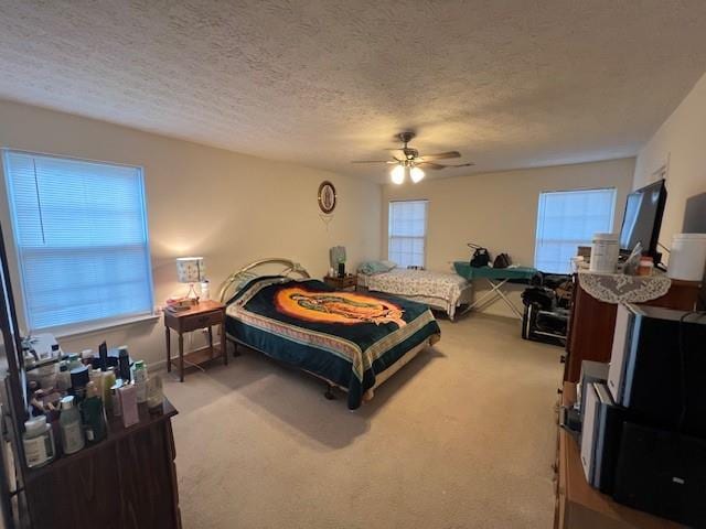 carpeted bedroom featuring a textured ceiling and ceiling fan