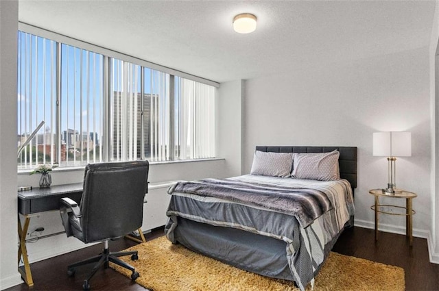 bedroom with dark hardwood / wood-style flooring and multiple windows