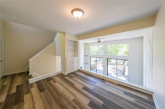 bonus room featuring built in shelves and dark hardwood / wood-style floors