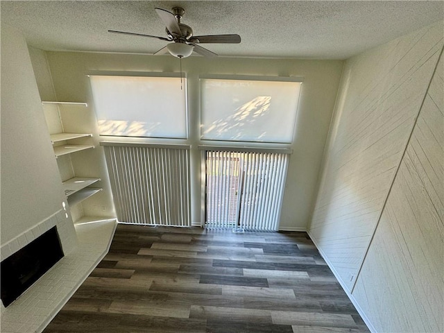 spare room with ceiling fan, dark wood-type flooring, and a textured ceiling