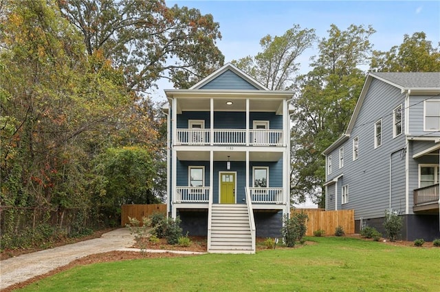 view of front of home with a front yard, a balcony, and a porch