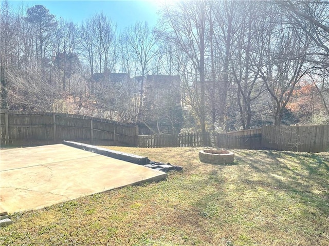 view of yard featuring a fenced backyard and a fire pit