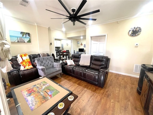 living area with ceiling fan, visible vents, crown molding, and wood finished floors