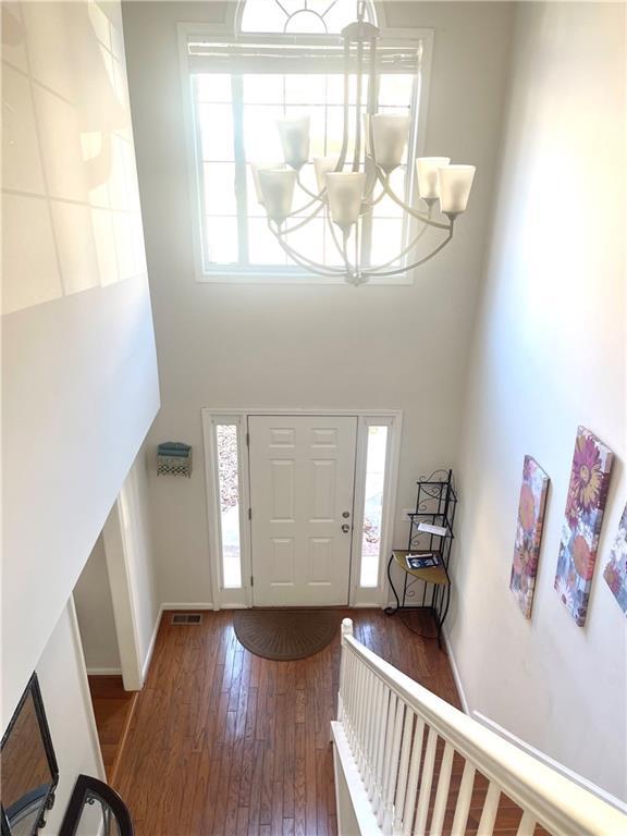 foyer featuring a chandelier, a high ceiling, hardwood / wood-style flooring, and baseboards