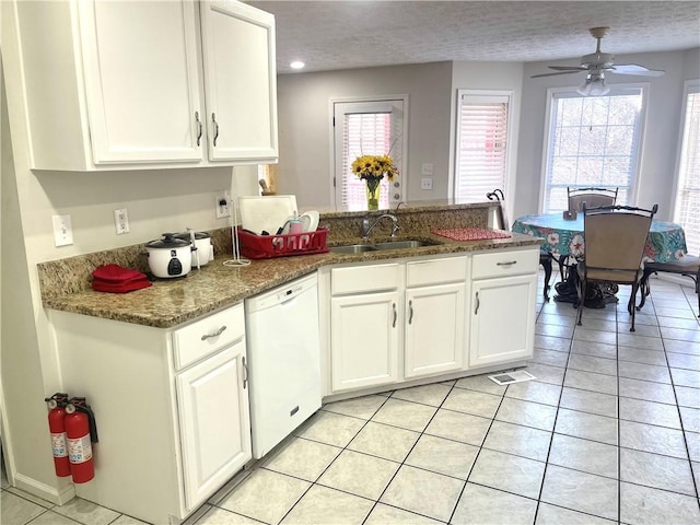 kitchen with white cabinetry, white dishwasher, a peninsula, and a sink