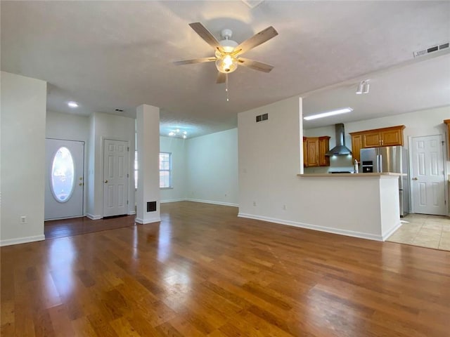 unfurnished living room featuring ceiling fan and light wood-type flooring