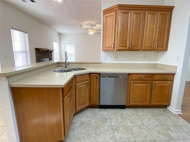 kitchen with light tile patterned flooring, a fireplace, dishwasher, sink, and ceiling fan