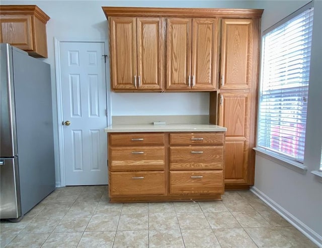 kitchen featuring light tile patterned floors and stainless steel fridge