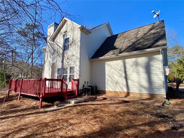 back of house with a wooden deck and central AC