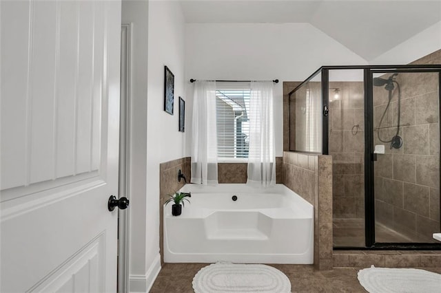 bathroom with tile patterned floors, independent shower and bath, and vaulted ceiling