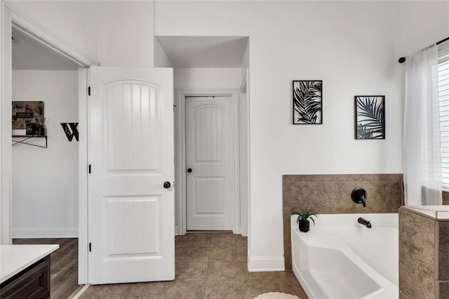 bathroom featuring a washtub, vanity, and tile patterned flooring