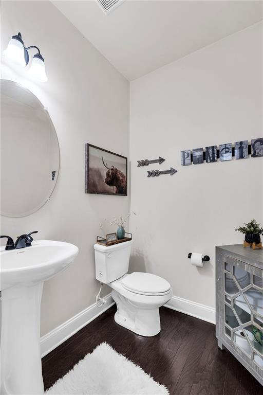 bathroom featuring toilet, wood-type flooring, and sink