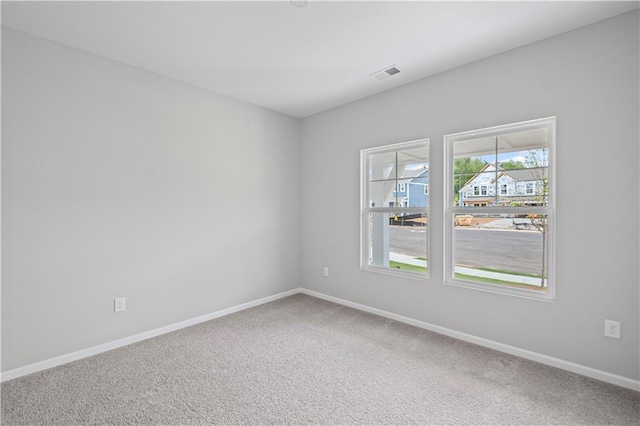 unfurnished room with visible vents, baseboards, and carpet floors