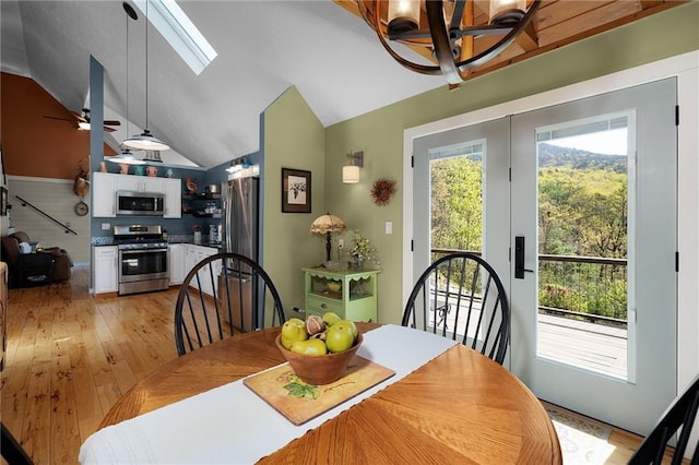 306 Pig Trl, Cherry Log, GA 30522 - dining room featuring lofted ceiling with skylight, ceiling fan with notable chandelier, and light wood-type flooring