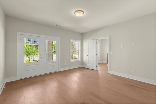 1417 Coretta Scott Bnd, Atlanta, GA 30318 - empty room featuring light wood finished floors, baseboards, and french doors