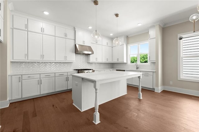 1417 Coretta Scott Bnd, Atlanta, GA 30318 - kitchen with under cabinet range hood, light countertops, white cabinets, backsplash, and crown molding
