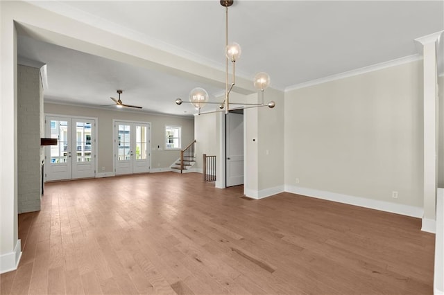 1417 Coretta Scott Bnd, Atlanta, GA 30318 - unfurnished living room featuring ornamental molding, light wood finished floors, baseboards, stairs, and a chandelier