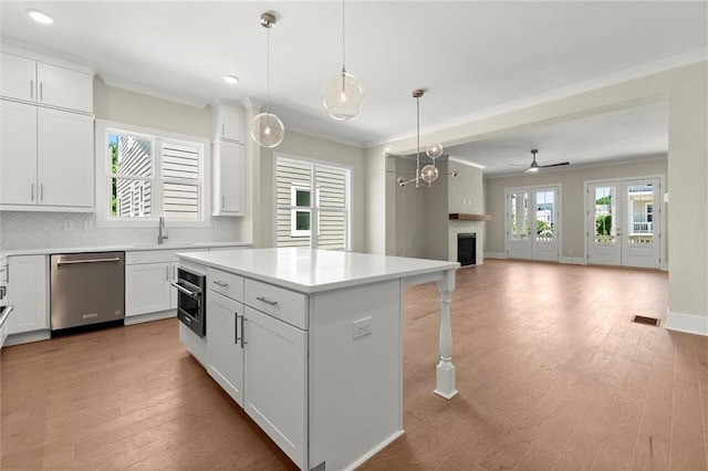 1417 Coretta Scott Bnd, Atlanta, GA 30318 - kitchen with dishwasher, a sink, a large fireplace, white cabinets, and a kitchen island
