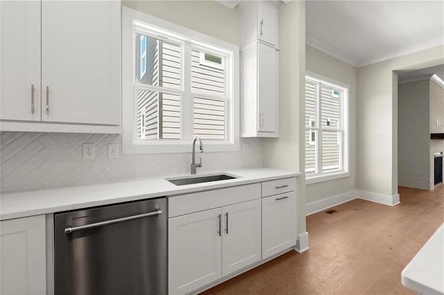 1417 Coretta Scott Bnd, Atlanta, GA 30318 - kitchen with stainless steel dishwasher, a sink, tasteful backsplash, light wood-style floors, and baseboards