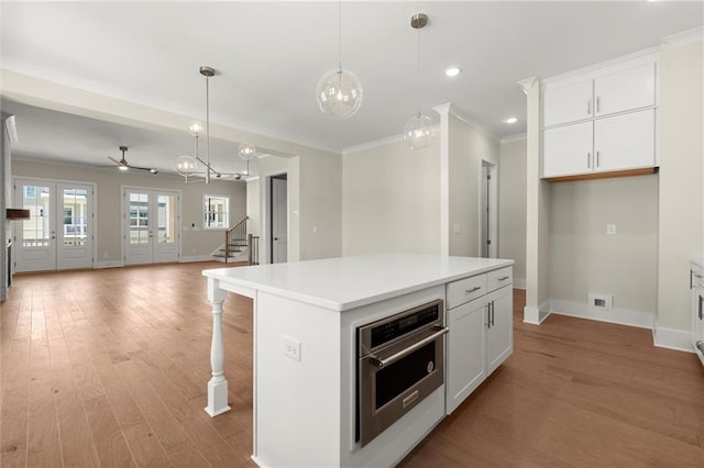 1417 Coretta Scott Bnd, Atlanta, GA 30318 - kitchen with stainless steel oven, baseboards, crown molding, light wood-style floors, and open floor plan