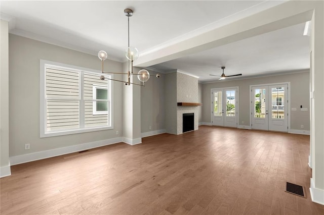 1417 Coretta Scott Bnd, Atlanta, GA 30318 - unfurnished living room with crown molding, a large fireplace, a chandelier, baseboards, and wood finished floors