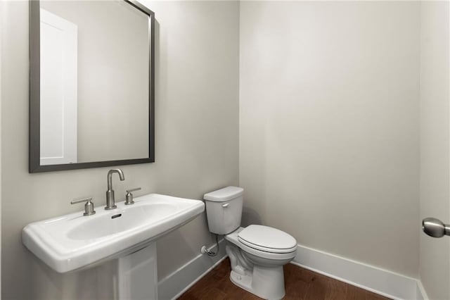 1417 Coretta Scott Bnd, Atlanta, GA 30318 - half bath with baseboards, wood finished floors, toilet, and a sink