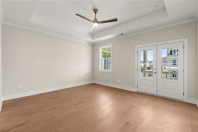 1417 Coretta Scott Bnd, Atlanta, GA 30318 - empty room featuring a tray ceiling, french doors, a ceiling fan, light wood-style flooring, and ornamental molding