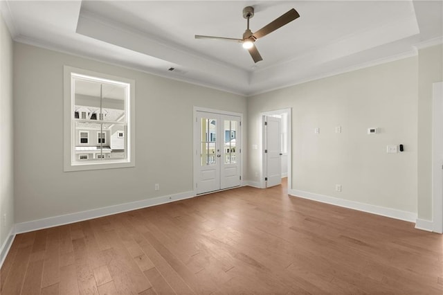 1417 Coretta Scott Bnd, Atlanta, GA 30318 - spare room featuring a tray ceiling, crown molding, wood finished floors, ceiling fan, and baseboards