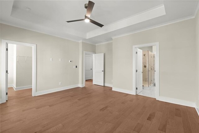 1417 Coretta Scott Bnd, Atlanta, GA 30318 - unfurnished bedroom with crown molding, light wood-type flooring, a walk in closet, a raised ceiling, and baseboards
