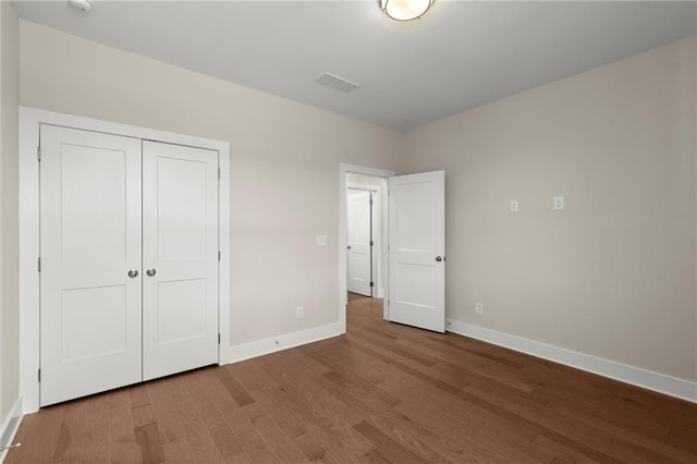 1417 Coretta Scott Bnd, Atlanta, GA 30318 - unfurnished bedroom featuring wood finished floors, baseboards, and a closet
