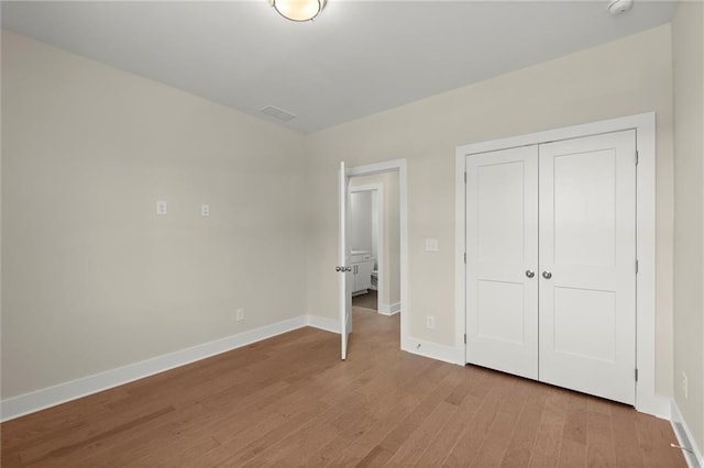 1417 Coretta Scott Bnd, Atlanta, GA 30318 - unfurnished bedroom featuring light wood-style floors, baseboards, and a closet