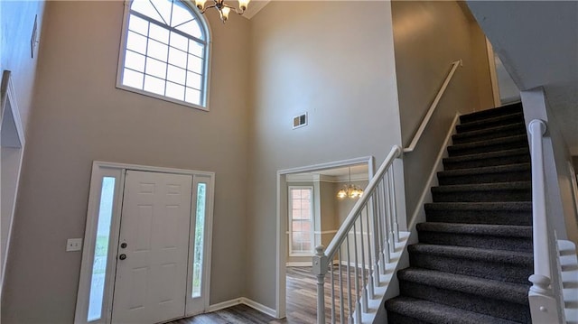 4373 Abram Dr, Conley, GA 30288 - entrance foyer featuring a chandelier, stairway, a towering ceiling, wood finished floors, and baseboards