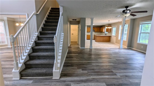 4373 Abram Dr, Conley, GA 30288 - stairs with a chandelier, baseboards, wood finished floors, a textured ceiling, and a ceiling fan