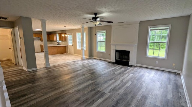4373 Abram Dr, Conley, GA 30288 - unfurnished living room with baseboards, dark wood-style flooring, a fireplace with flush hearth, ceiling fan, and a textured ceiling