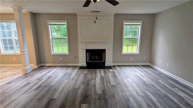 4373 Abram Dr, Conley, GA 30288 - unfurnished living room with wood finished floors, a ceiling fan, a textured ceiling, a fireplace with flush hearth, and baseboards