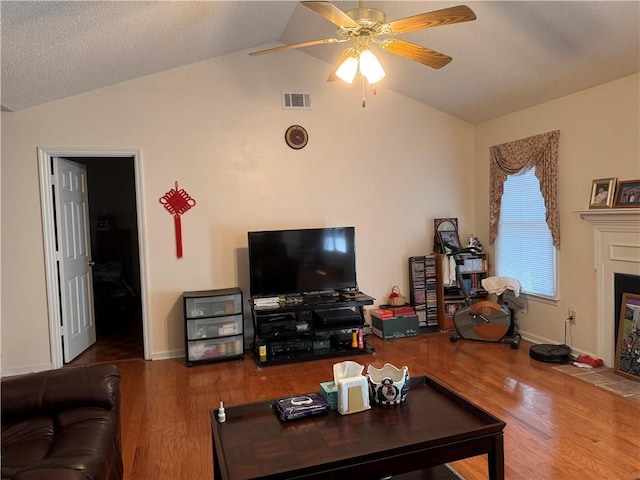 living room with ceiling fan, wood-type flooring, and vaulted ceiling